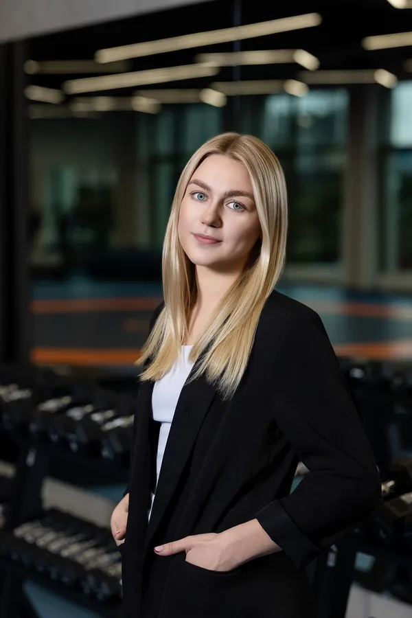 Portrait of a woman in a black blazer at a gym