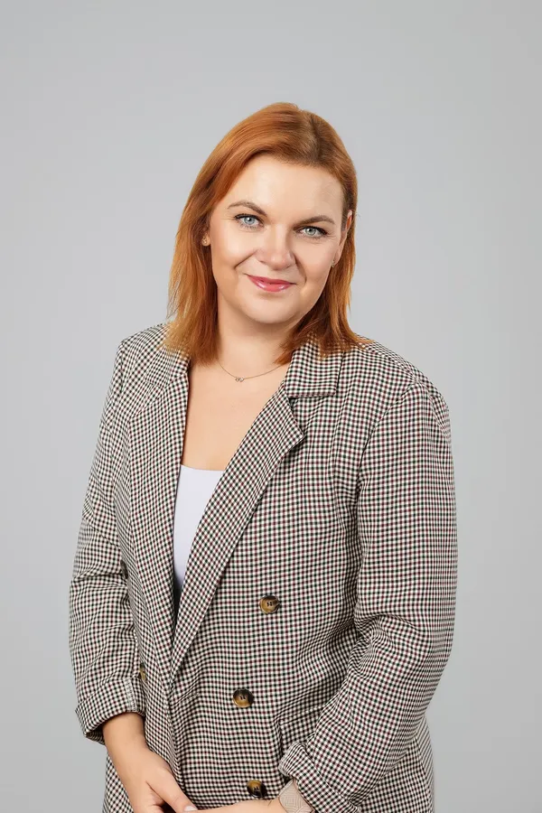 Portrait of a woman in a checked blazer on a grey studio background