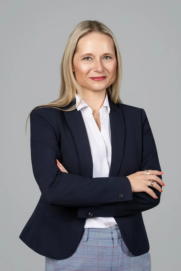 Business portrait of a woman in a dark blazer on a grey background