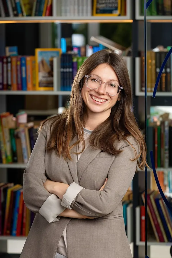 Portrait of a woman with glasses against an office bookcase