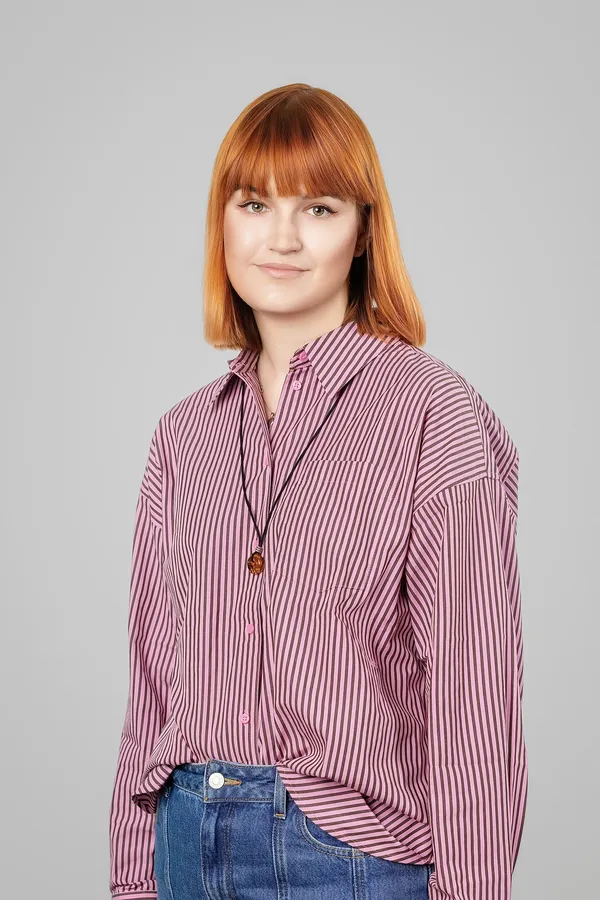 Portrait of a woman in a striped shirt on a grey background