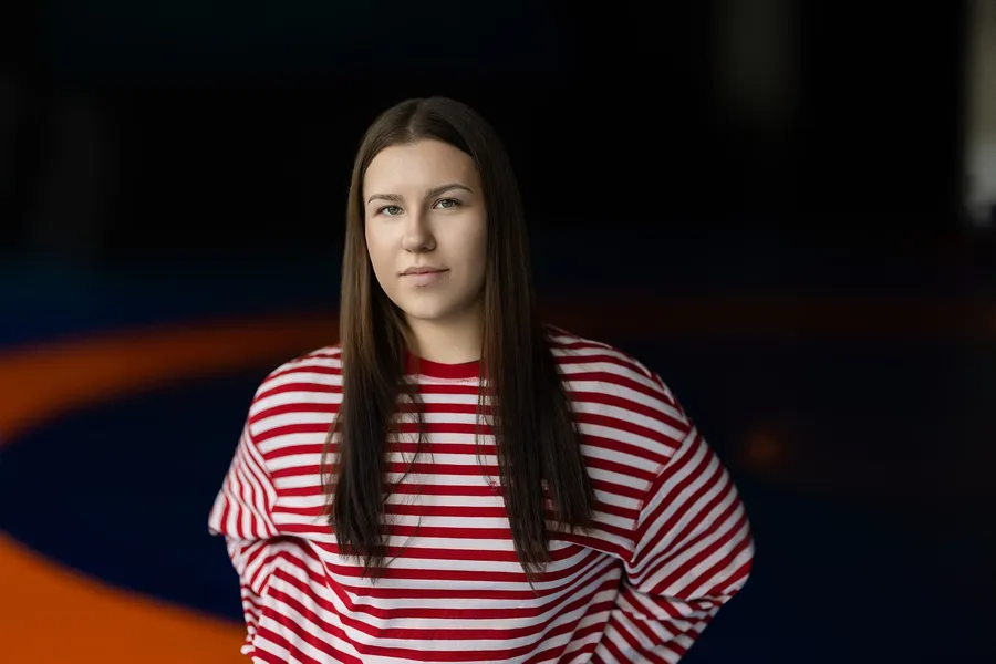 Portrait of a woman in a striped jumper in a dark sports arena