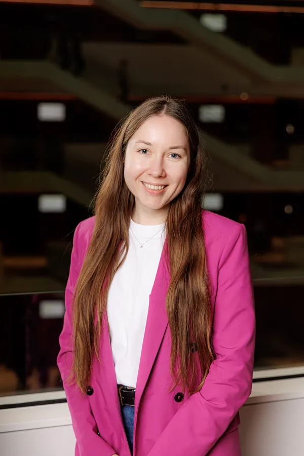 Woman in a magenta blazer in an office atrium