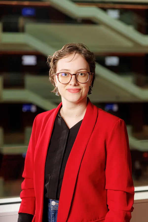 Woman with glasses in a red blazer in an office atrium